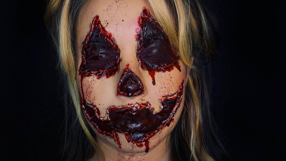 A woman that appears to have carved into her own skin with blood visible