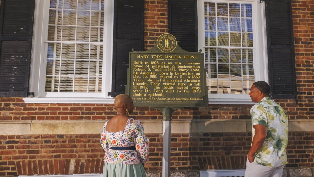 Two people standing and reading a sign outside of the Mary Todd Lincoln House.