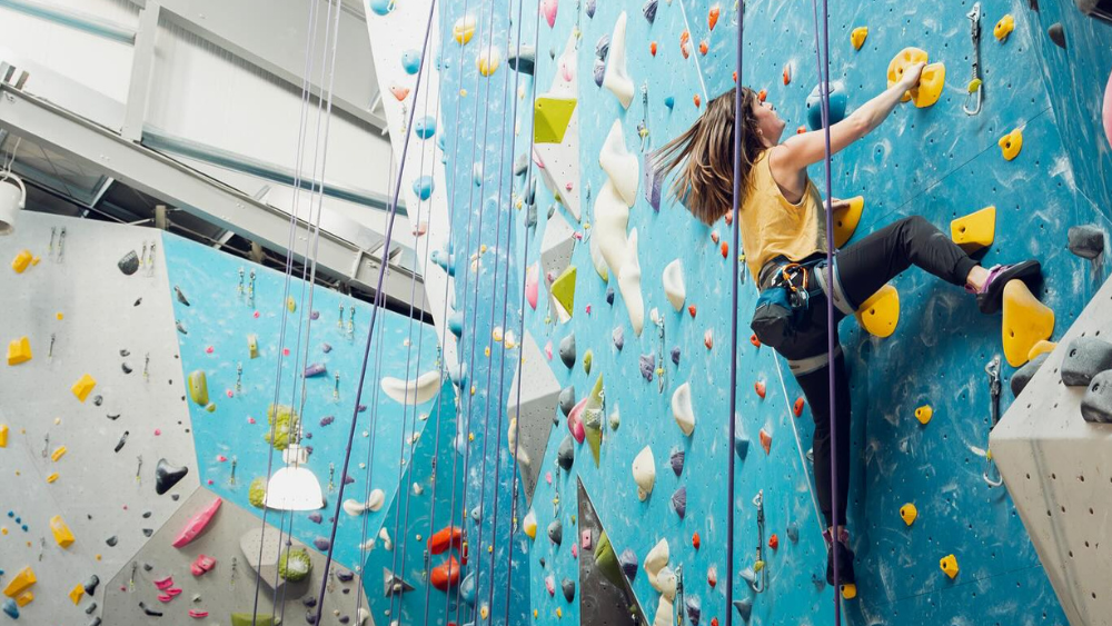 A climber makes their way up an indoor rock wall at Movement in Portland, Oregon.