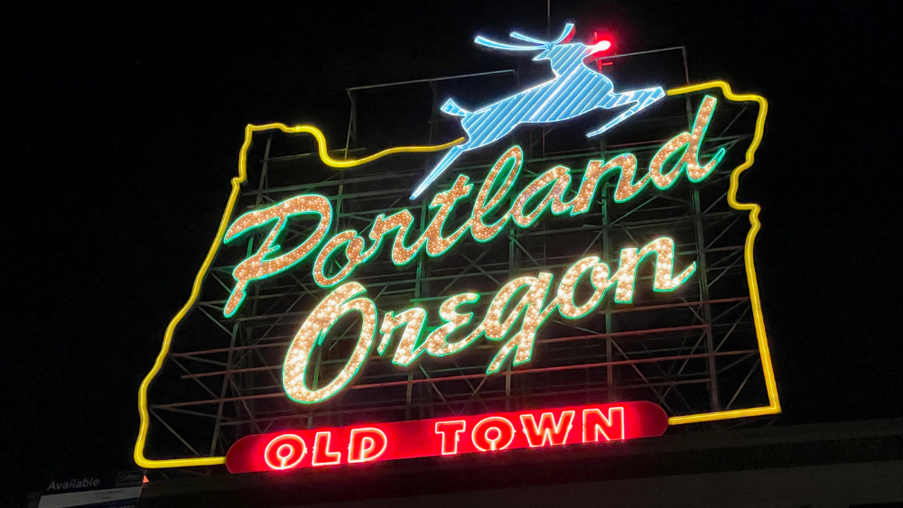 A neon sign in the outline of Oregon with the words