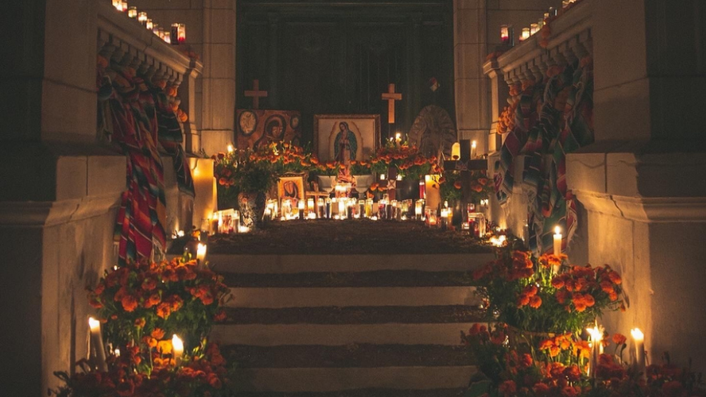 Pictured is the altar of a past Day of the Dead celebration, complete with lit candles and gifts.