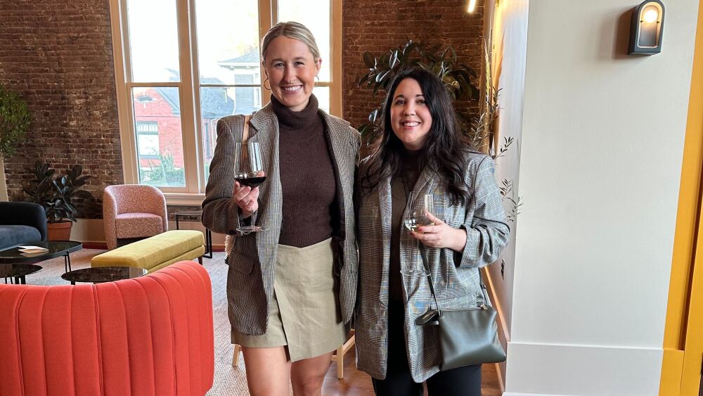 City Editors Skylar and Dylan stand next to each other holding drinks.