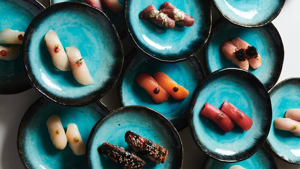 An arrangement of sushi dishes on artsy porcelain plates