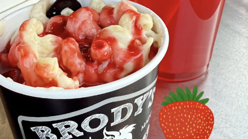 A cup of strawberry mac and cheese with an iced strawberry drink