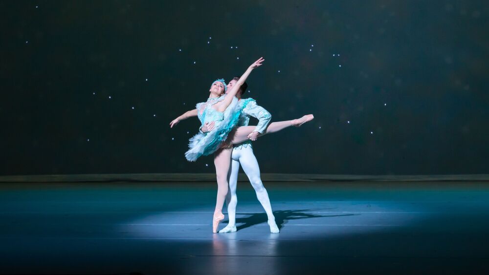 Two dancers perform on stage.