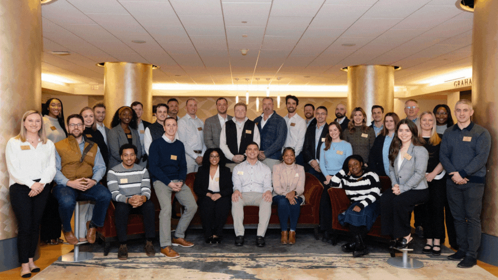 A large group looking at the camera. A smaller group raising their hands and laughing. A person asking a question in a classroom.