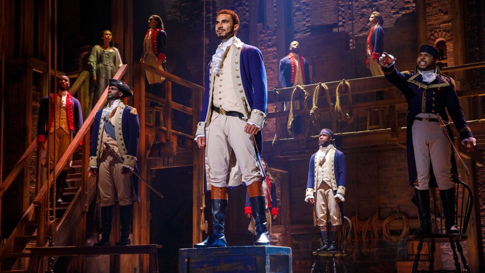 Actors perform Hamilton onstage. 