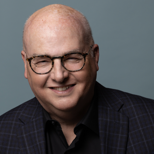 David Warner wearing a plaid suit jacket