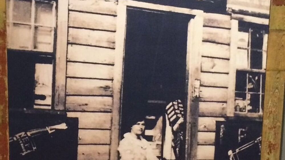 This photo shows another much older photo of the original Harold’s Cabin. 