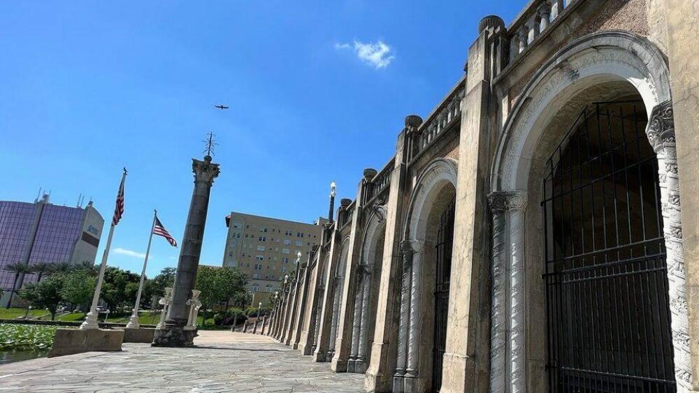 A loggia with gated arches and columns on the Frances Langford Promenade under a clear blue sky.