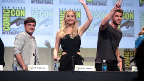 The cast of The Hunger Games waves to the crowd at Comic Con.