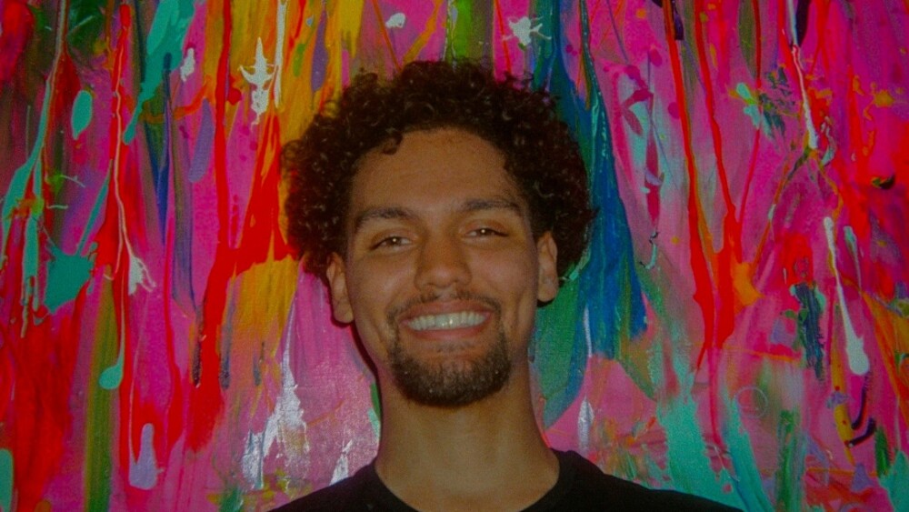 Film portrait of Aaron Christmas with a multicolor background.