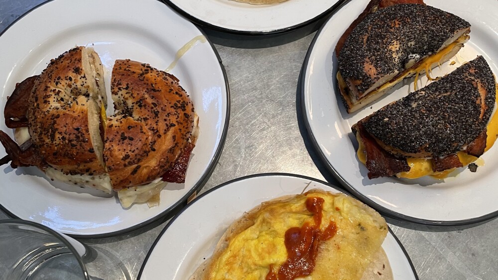 Four plates featuring bagels and breakfast tacos at Pearl's