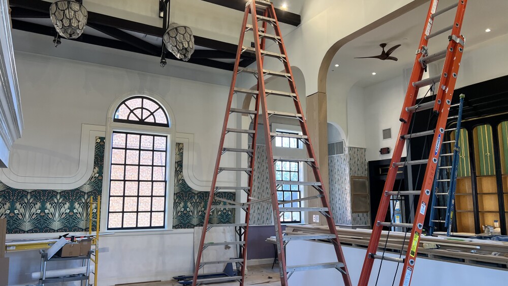 Ladders stand erect inside an ongoing development project inside a high-ceiling building.