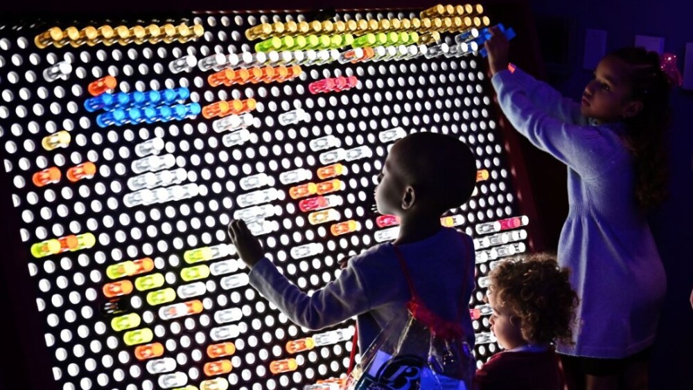 Photo of kid standing in front of a large interactive light game.