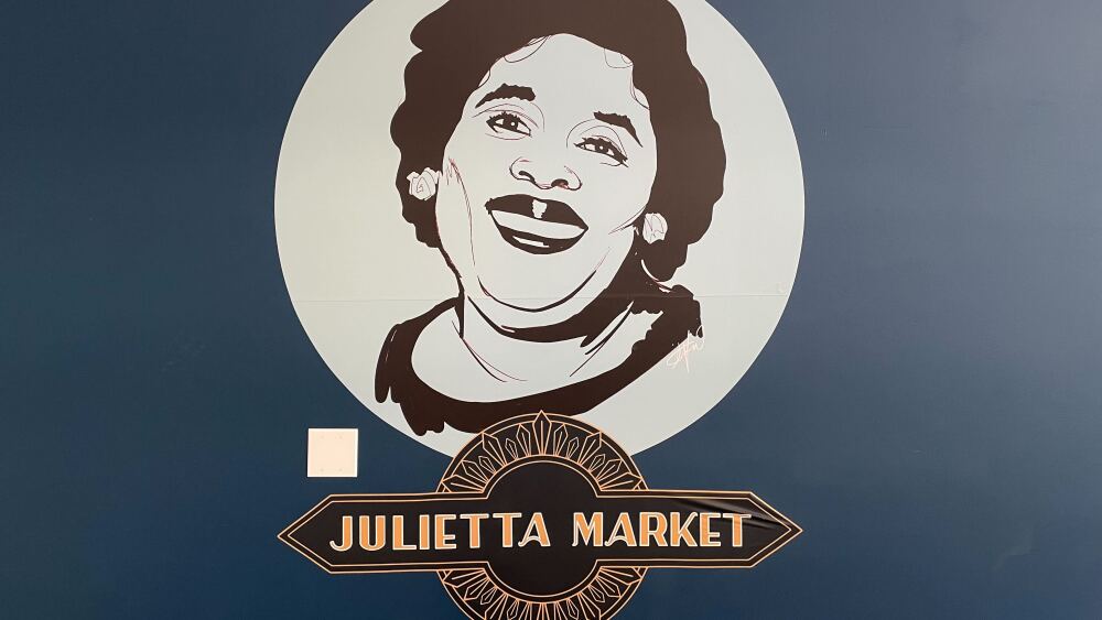 A painted wall with Julietta's face and logo on it