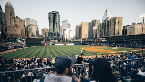 A couple watching a baseball game with a view of downtown Charlotte.