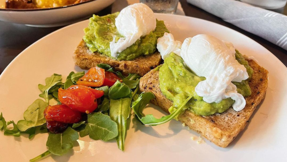 Two pieces of avocado toast with a micro salad