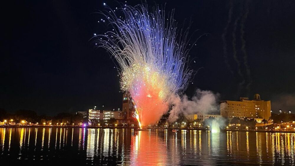 A burst of Red, White & Kaboom fireworks shoot off from the lake; downtown Lakeland's skyline reflects on the lake