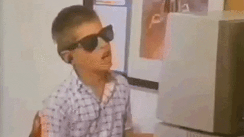 A gif of a young boy dancing while working on the computer.