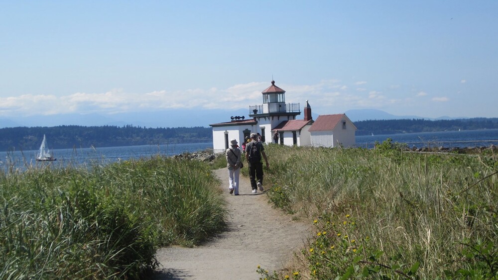 Discovery Park in Seattle with a lighthouse and the water in the background