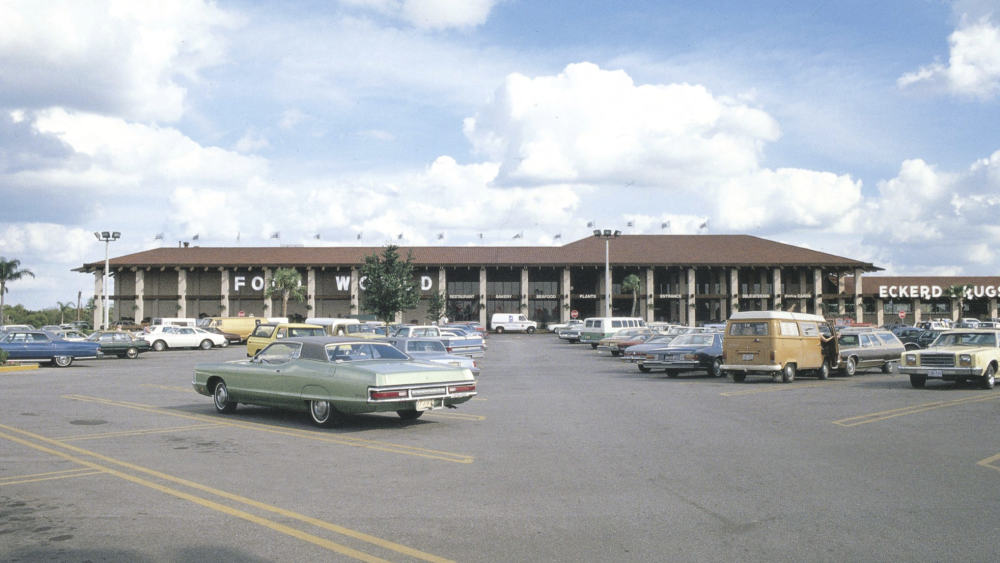 1970s photo of Food World in Lakeland, FL, with a parking lot full of classic cars and an Eckerd Drugs store in view.