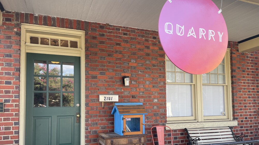 A porch with a chair, a door, a free library, and a sign reading "QUARRY"