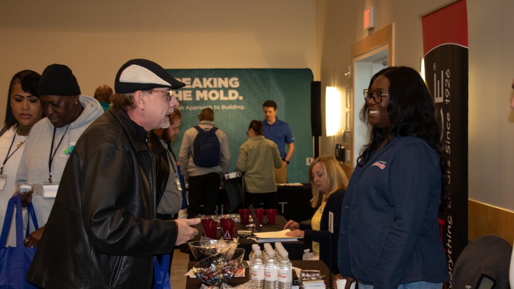 A job representative speaks to a job seeker at a career fair.