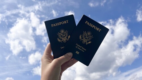 Two passports being held in the air.