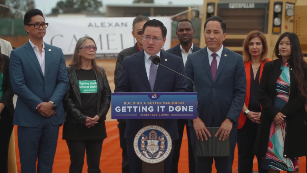 District 6 Councilmember Kent Lee stands at a podium with leader behind him to discuss changes to the Convoy District.