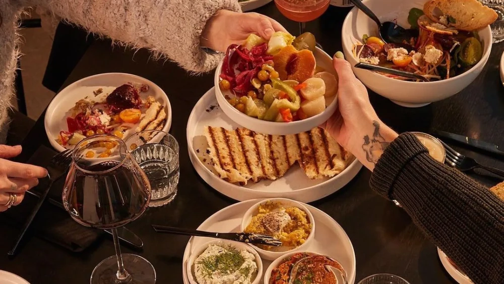 A dinner table featuring a variety of foods and drinks.