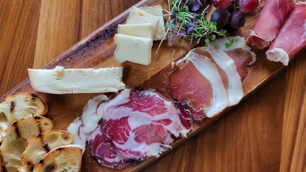 A charcuterie board with meats, cheese, and bread.