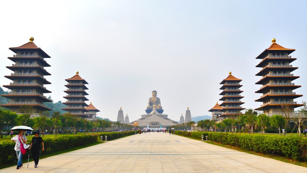 Pagodas line either side of a long walkway which ends in a massive Buddha statue at the Fo Guang Shan Buddha Museum.