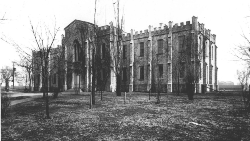 A black and white view of the exterior entrance of the former University of Nashville building, which features Gothic-like architecture.