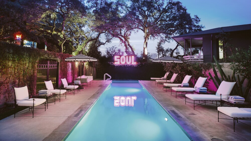The pool at Hotel Saint Cecilia, with a neon sign reading "SOUL" reflected in the water.