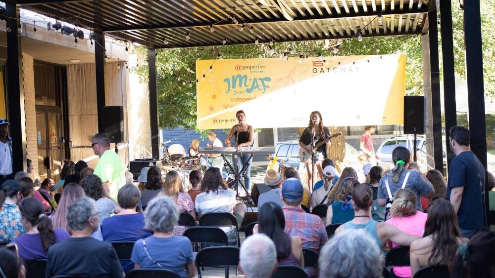 Crowd sitting in front of a stage with performers