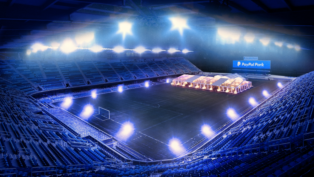 A wide view of the PayPal Park soccer stadium, with a large tent on the pitch.