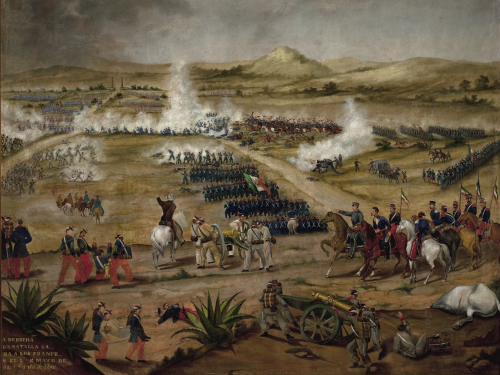 Painting of the Battle of Puebla on May 5, 1862, showing Mexican soldiers in traditional uniforms charging against French forces on horseback and foot, amid smoke and cannon fire, with a backdrop of mountains and a fortification.