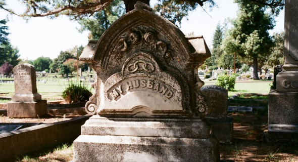 A gravestone reads "MY HUSBAND"