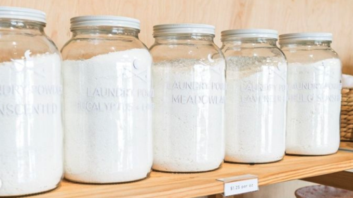 Glass jars of laundry powder on a shelf.