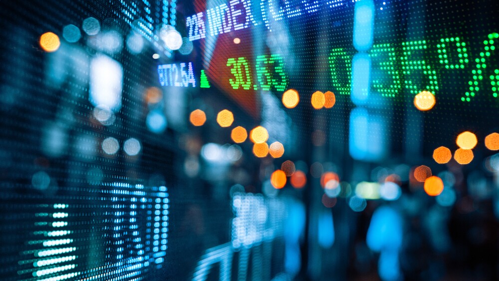 Display of Stock market quotes with city scene reflect on glass