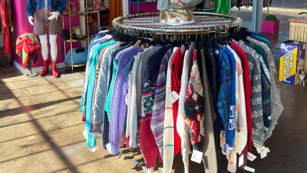 A rack of sweaters for sale at Vintage Therapy.