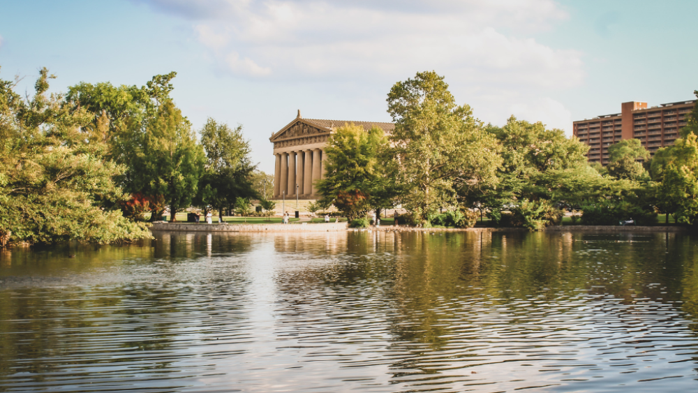 Centennial Park's Parthenon replica sits in the distance, partially covered by lush green trees. Lake Watauga takes up most of the frame.