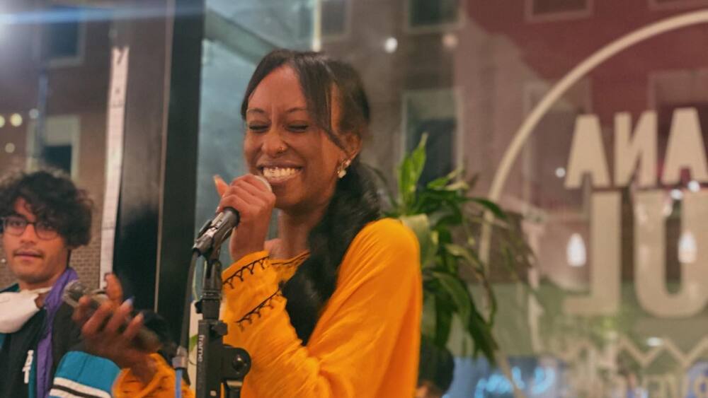 A woman smiles at the open mic in Nirvana Soul Cafe.