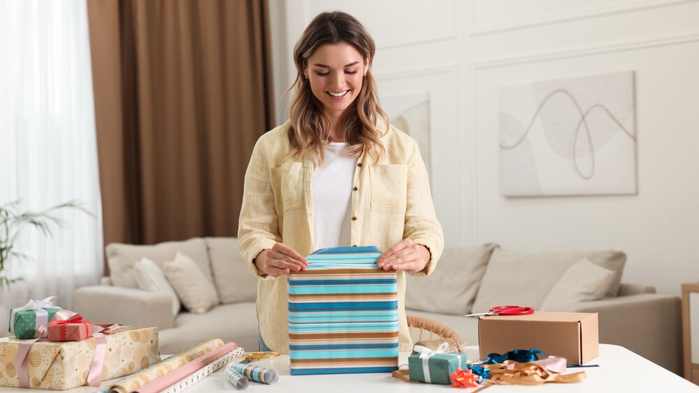 Young woman wrapping gifts at a table