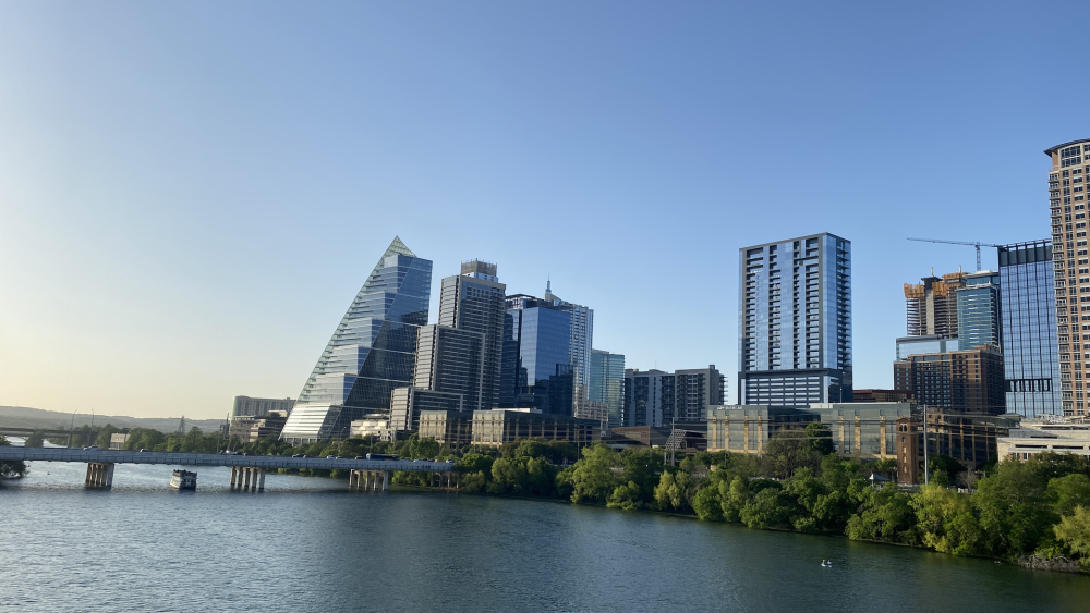 A view of the Austin skyline and Lady Bird Lake on a sunny day.