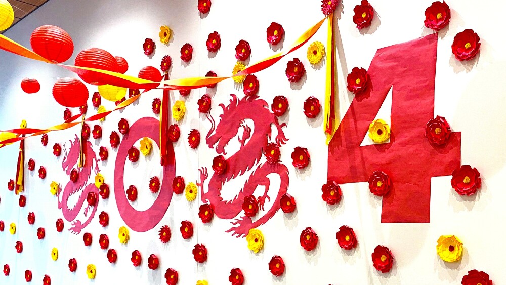 Photo of red and yellow paper Lunar New Year decorations on a library wall.