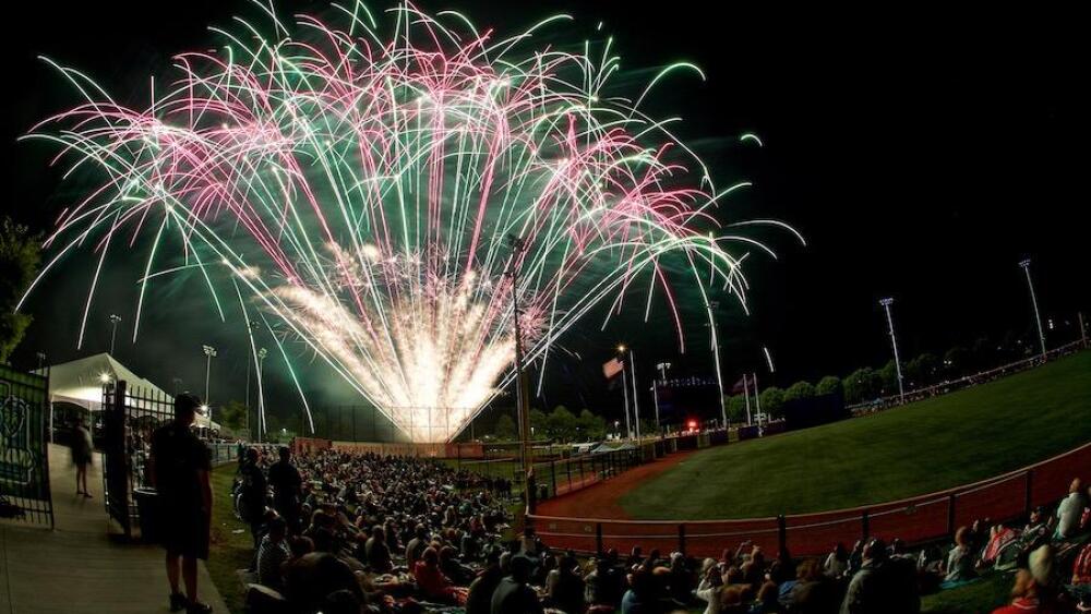 Fireworks shoot above a baseball stadium.