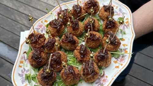 A plate of appetizers are served on a patio.