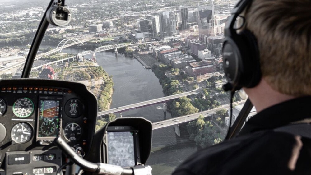 A pilot flies a helicopter over the Cumberland River and downtown Nashville.